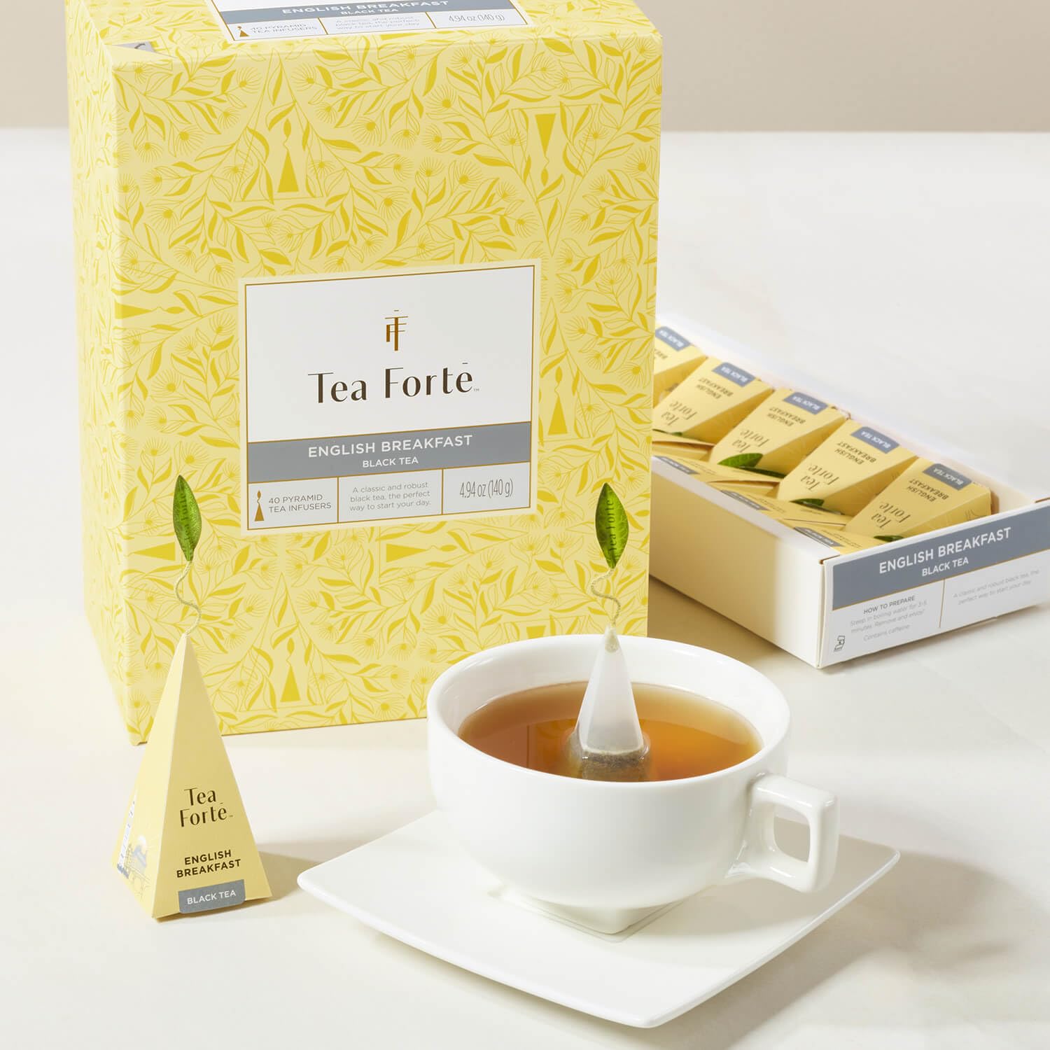 Tea Forte box beside a mug demonstrating portion size and storage benefit