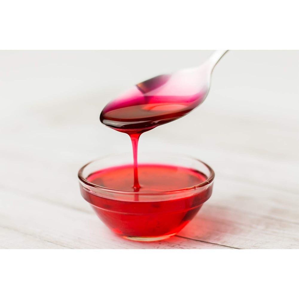 TEA ZONE raspberry syrup mixed into iced tea glass with vibrant color and refreshment