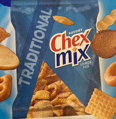 Hand holding 1.75oz bag of The Holy South Chex Mix for size and portability