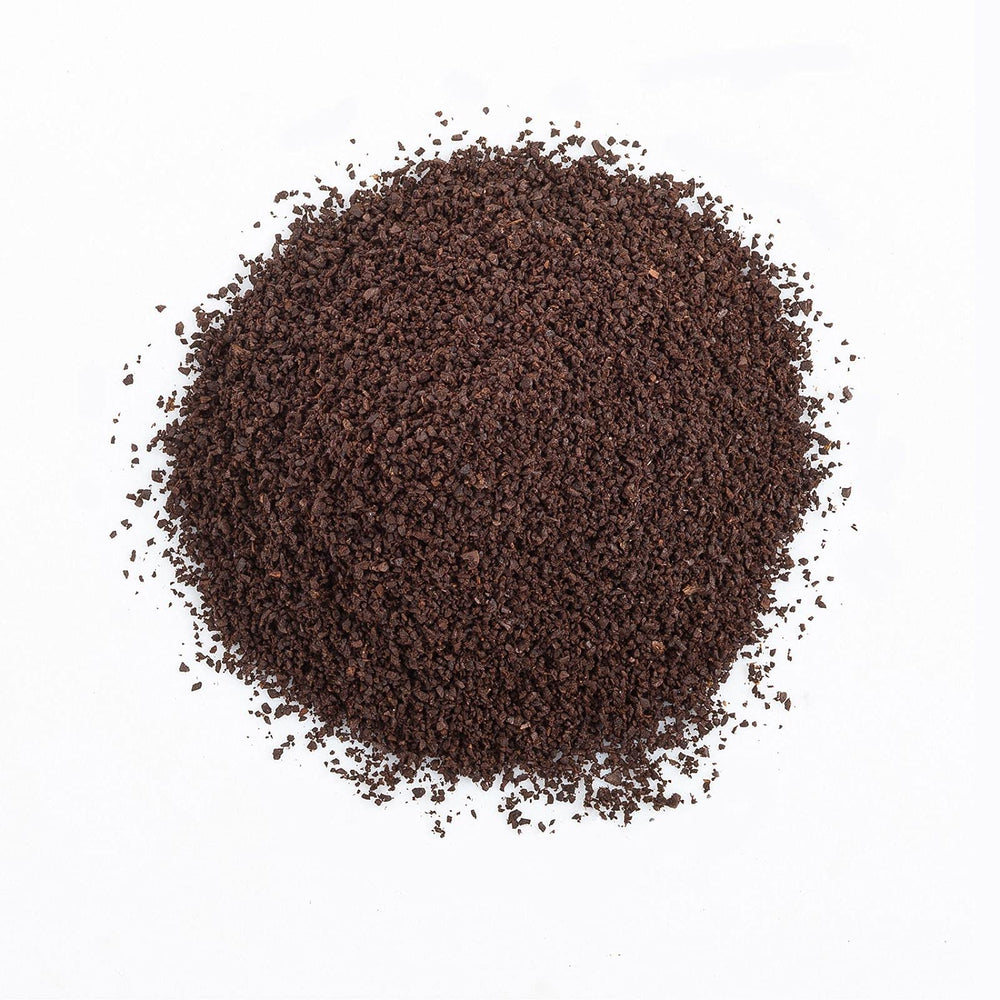 The Organic Coffee Co. grounds pouring to mug illustrating rich, balanced flavor