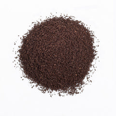 The Organic Coffee Co. grounds pouring to mug illustrating rich, balanced flavor