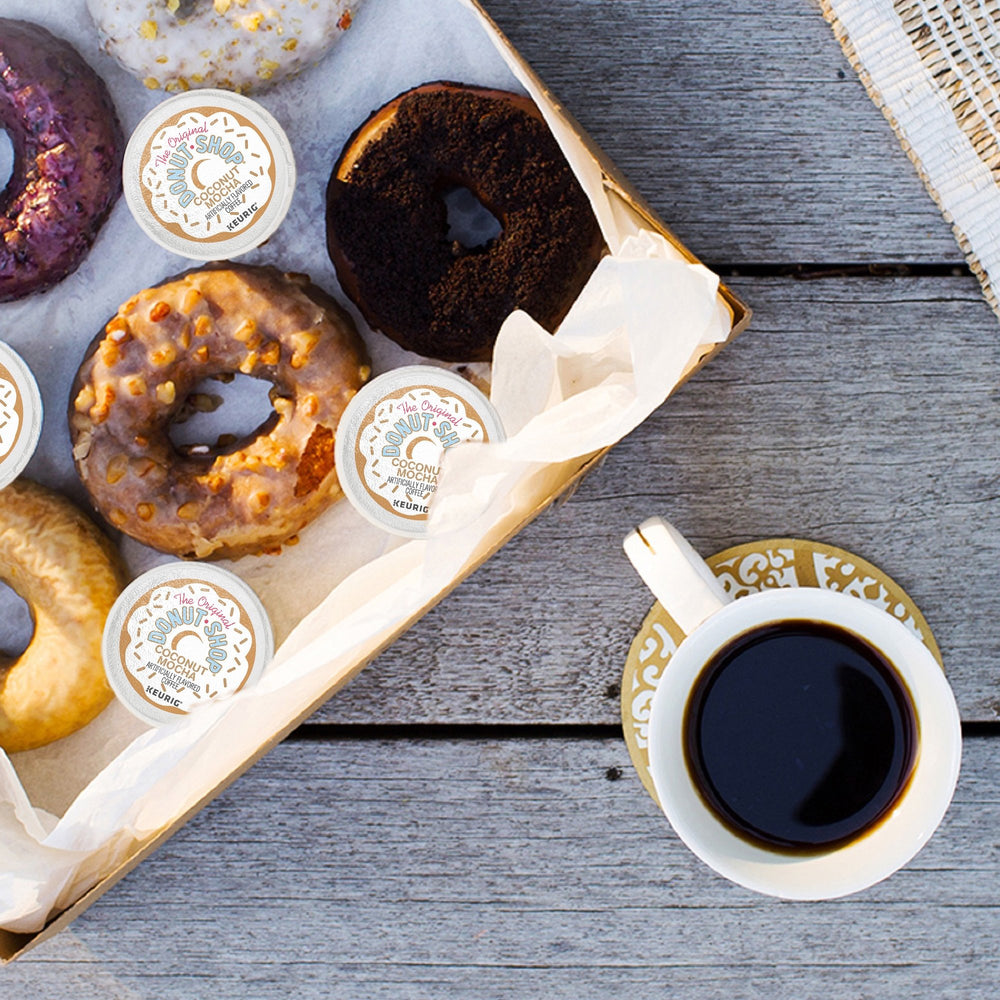 The Original Donut Shop pod size comparison in hand demonstrating compact convenience