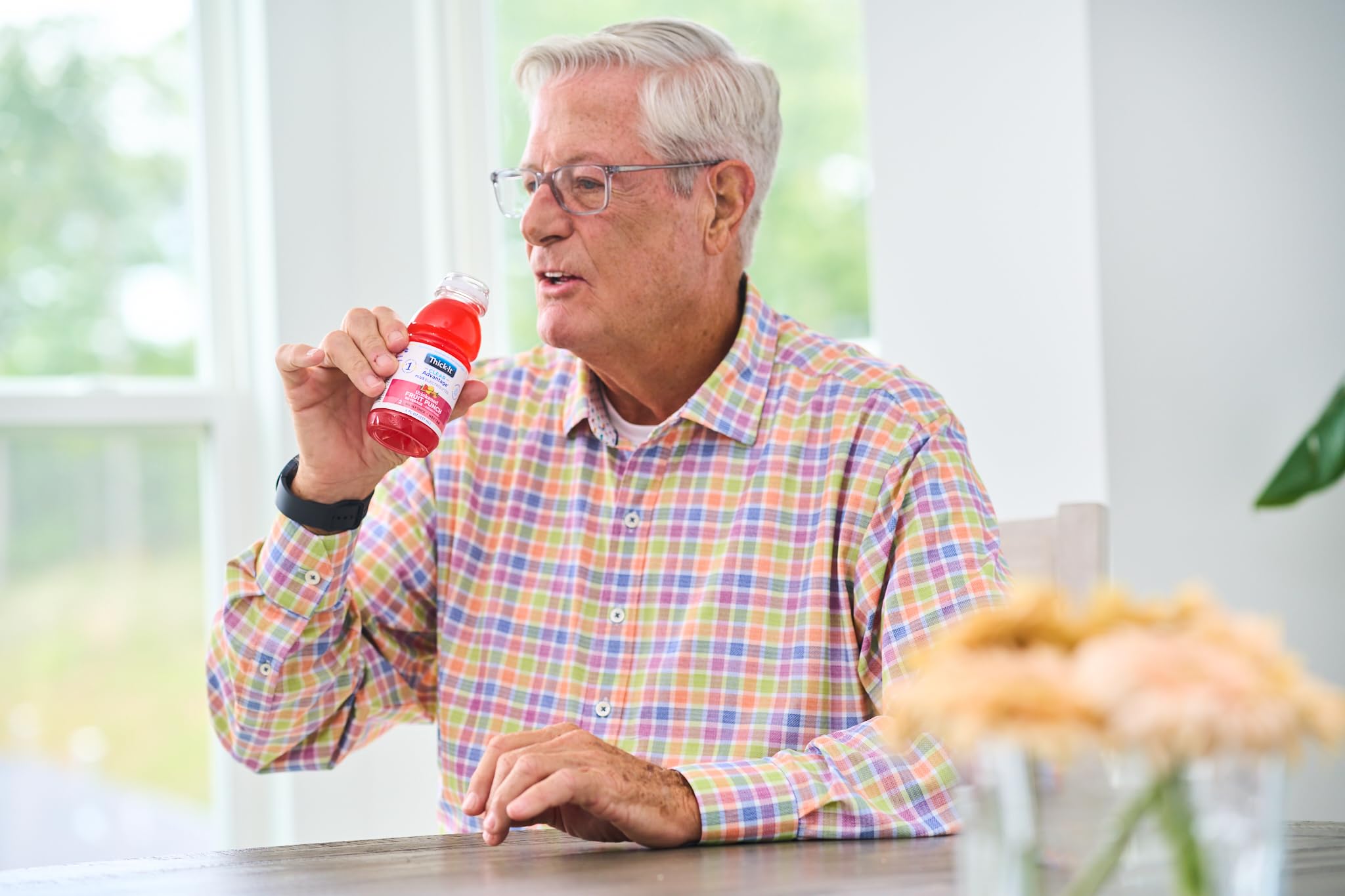 Thick-It caregiver serving bottle to resident highlighting convenient hydration