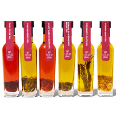 Thoughtfully six infused olive oil bottles lined up highlighting flavor variety and choice