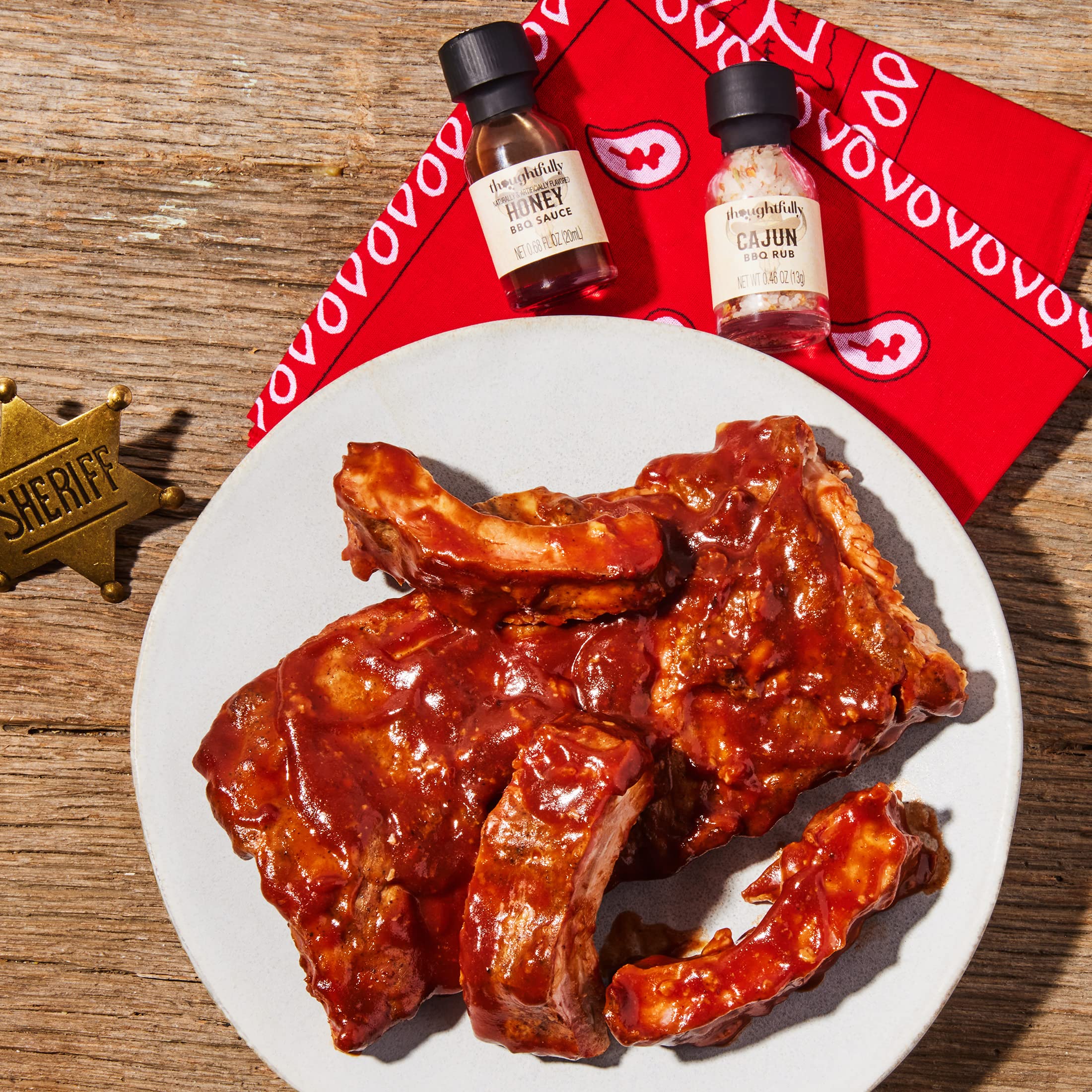 Thoughtfully pouring a mango-style sauce from a mini bottle onto grilled meat for glossy finish