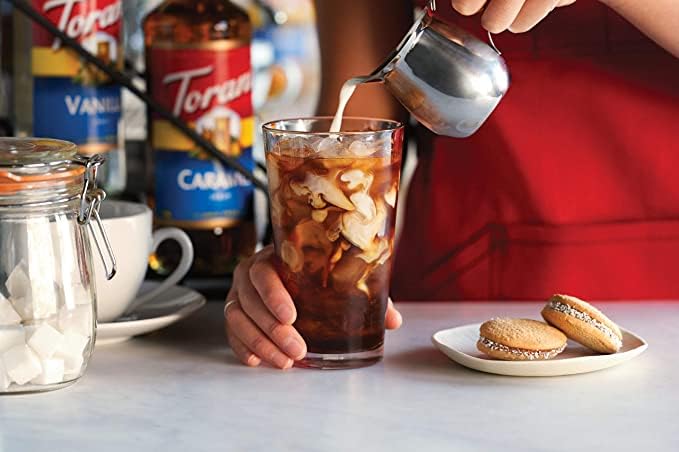 Torani bottle beside a coffee cup to show 750 ml size and usage benefit