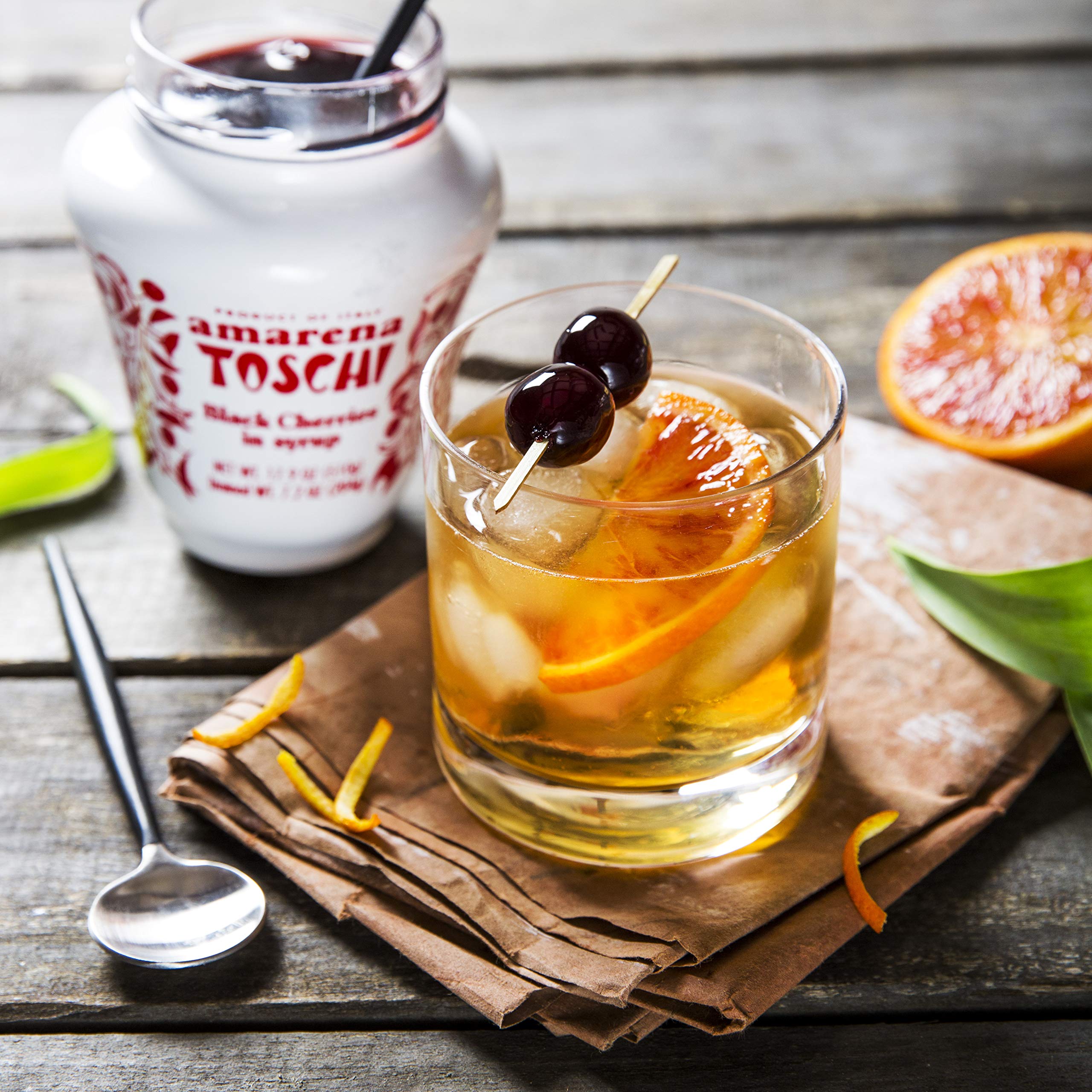 Pouring Toschi syrup from jar to show richness and easy cocktail use