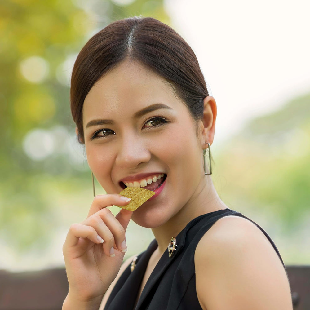 Person enjoying Triscuit crackers in casual setting emphasizing on-the-go snacking