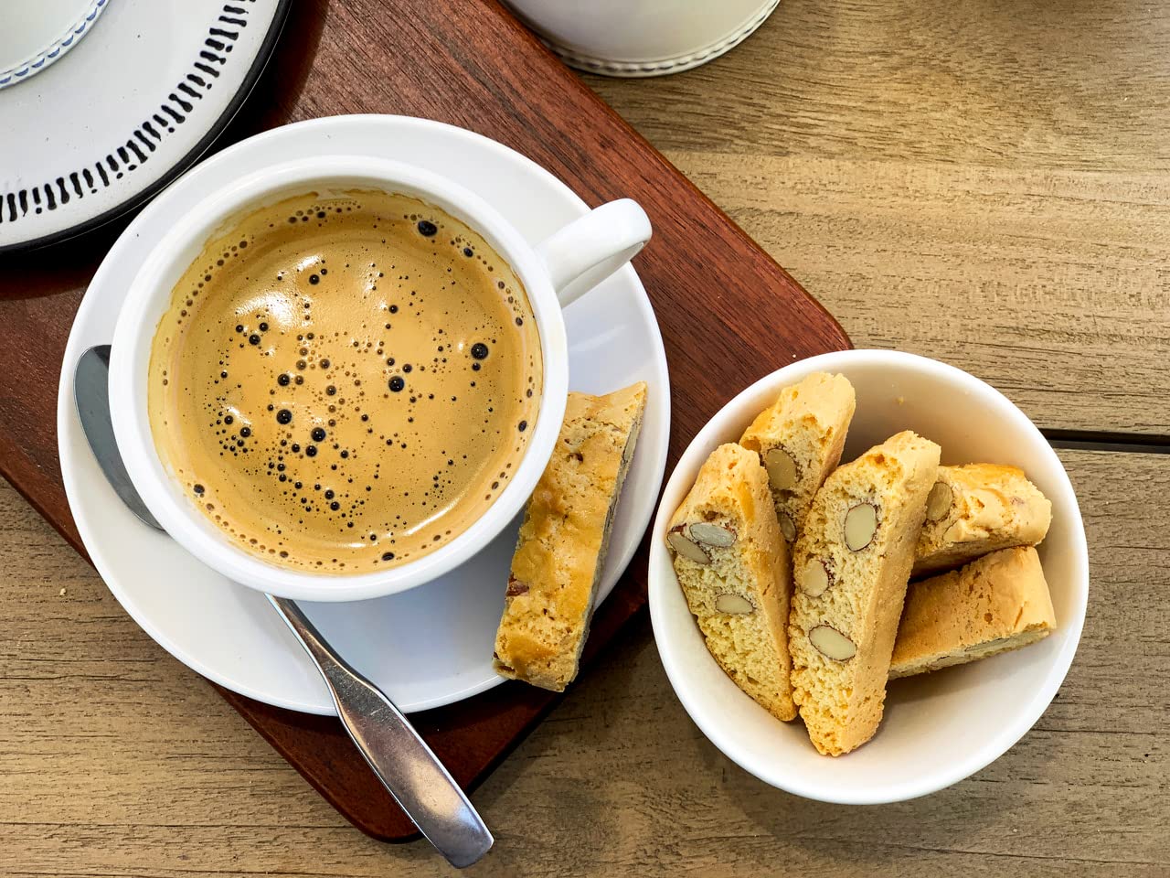 True Delicious hand holding biscotti to show cookie size and portion