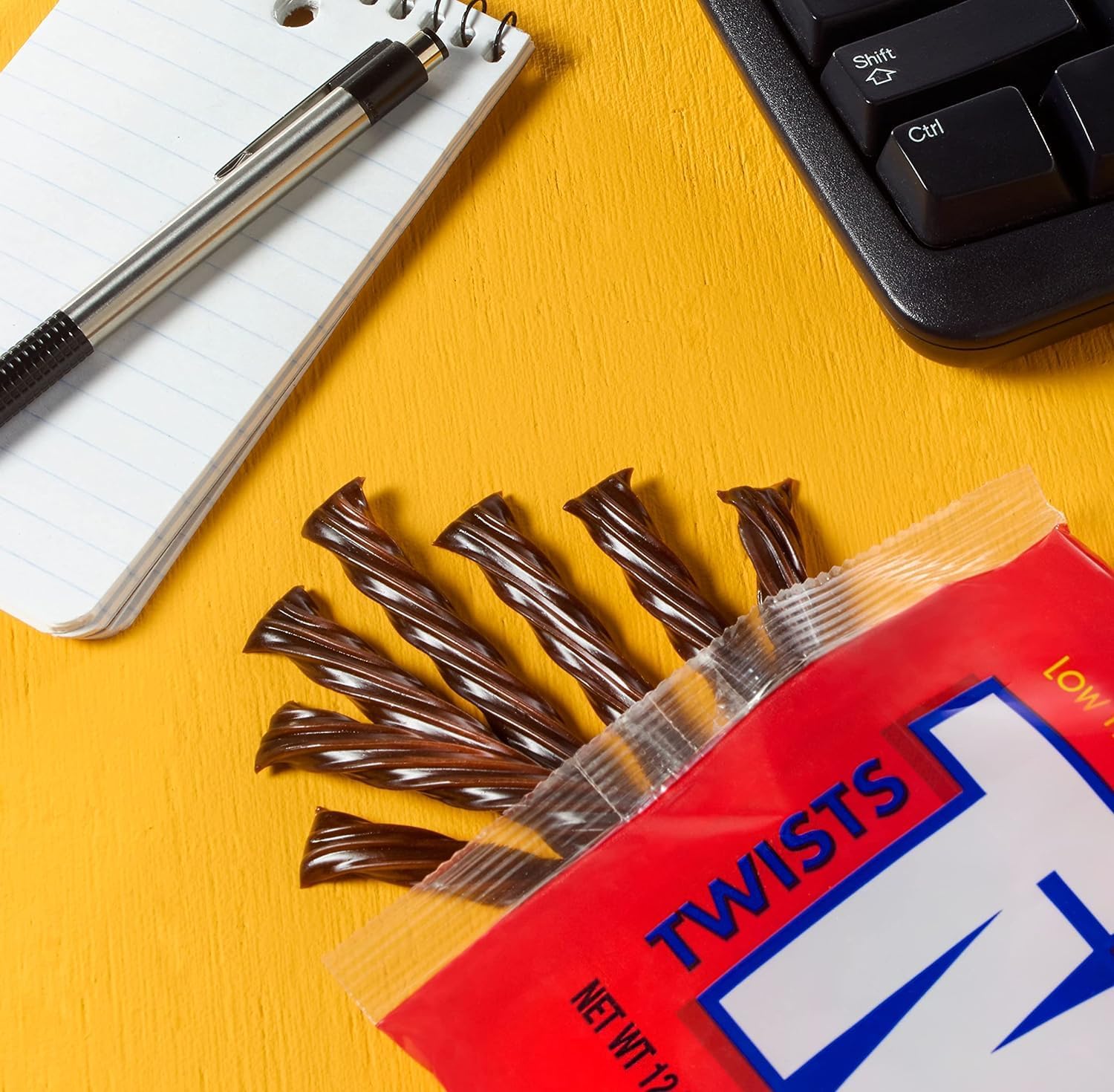 Hand holding a Twizzlers chocolate twist to show size and easy portioning