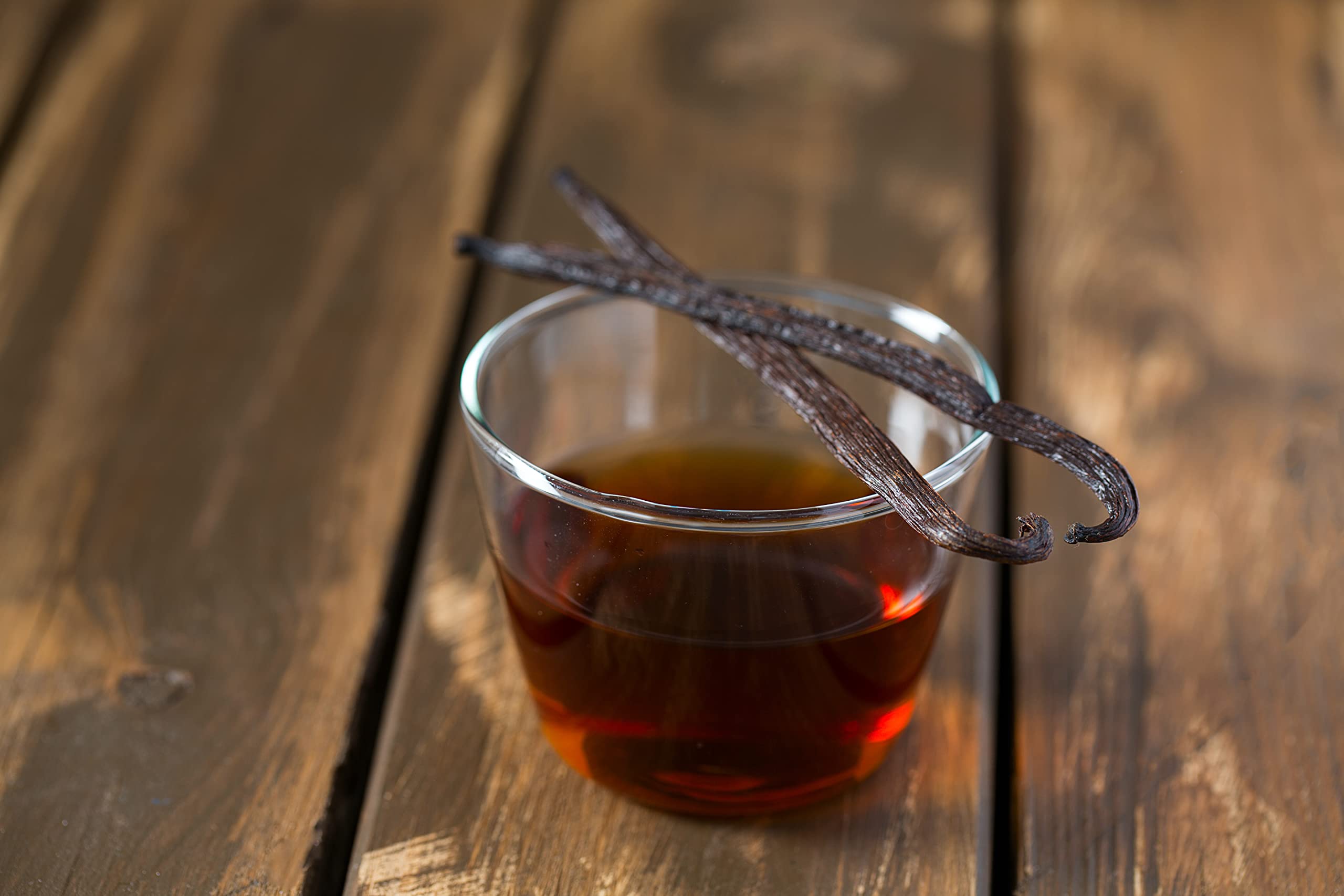 Vanilla Bean Kings pouring extract into spoon demonstrating concentrated flavor benefit