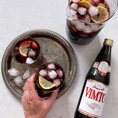 Vimto iced drink in glass with ice and garnish showing refreshing summer serve