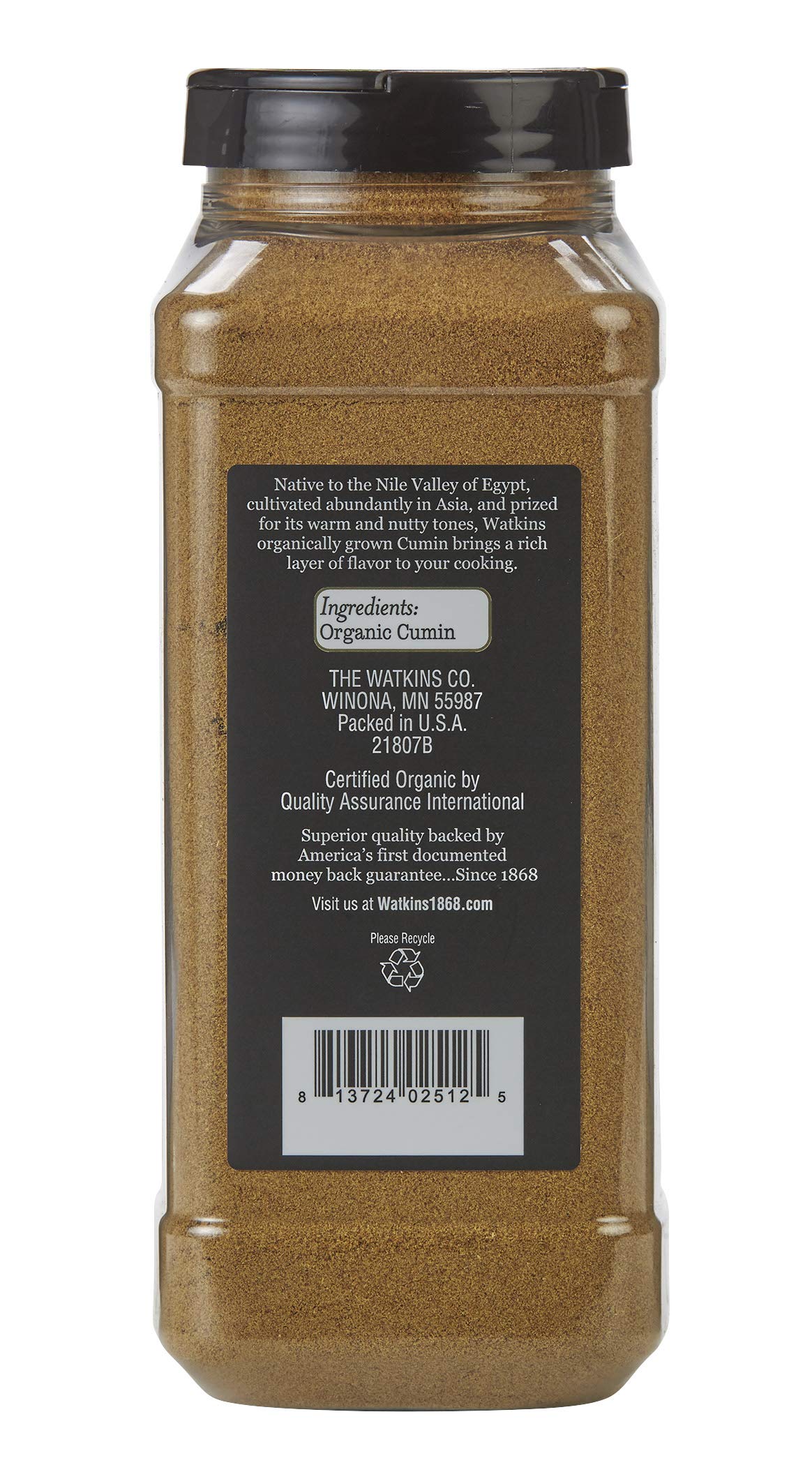 Watkins ground cumin pouring from bottle close-up highlights fine texture and aroma