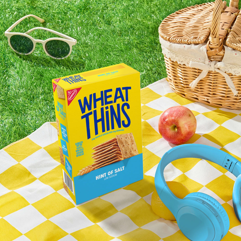 WHEAT THINS cracker in hand showing size and portable snack convenience