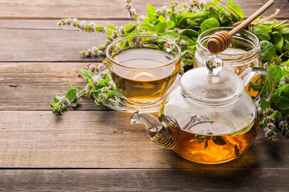 Worldwide Botanicals iced lemon balm tea in glass with lemon slice showing refreshing summer beverage