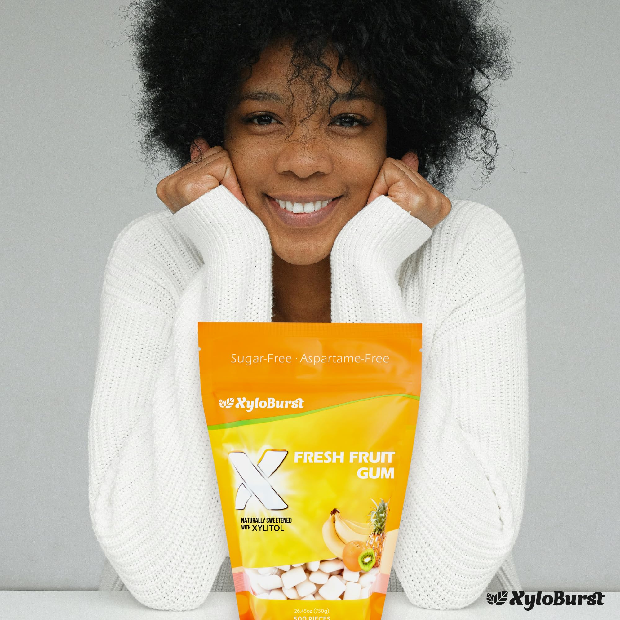 Xyloburst gum next to a ruler showing serving size and clear dosing of xylitol per piece