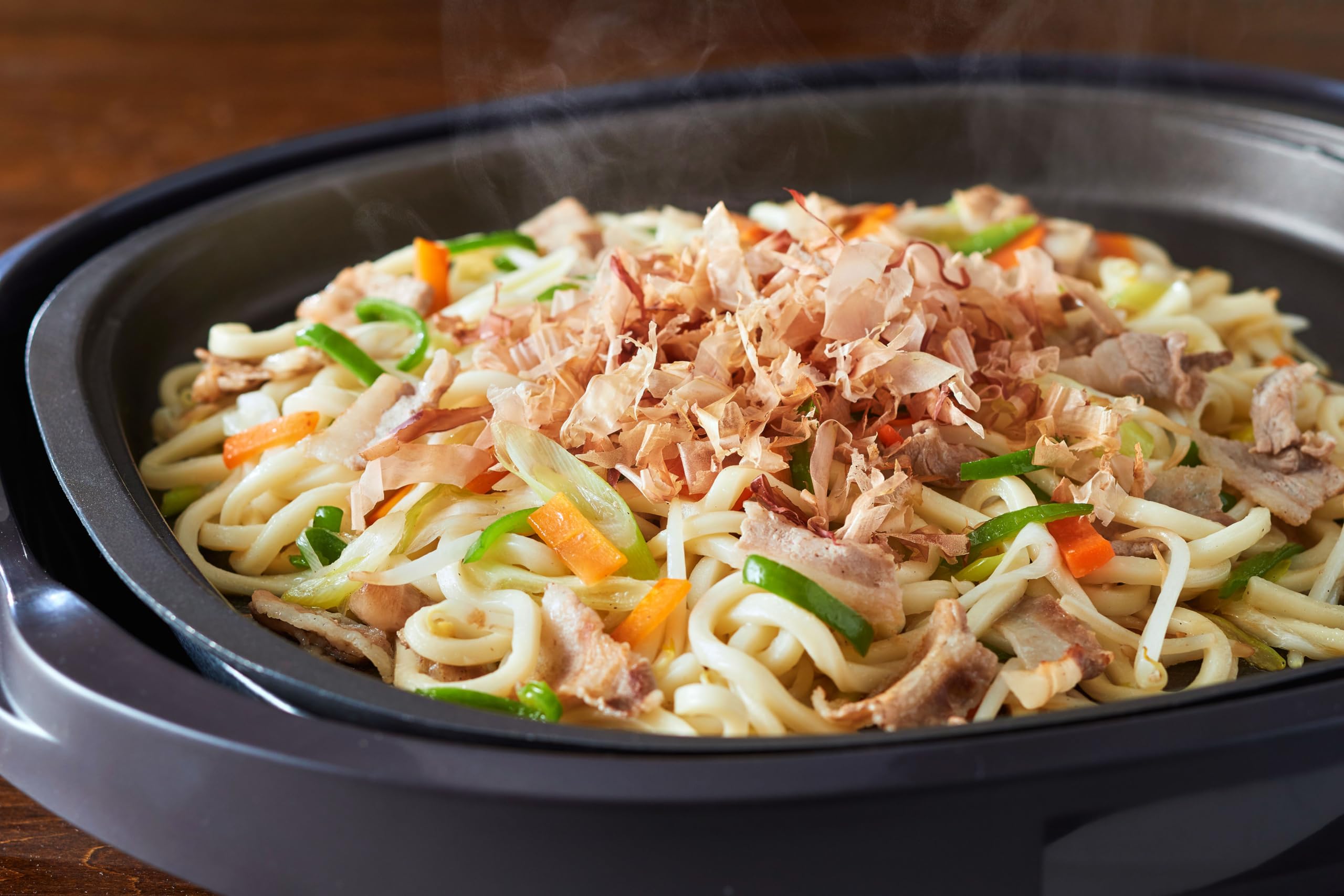 yamaki flakes being poured over rice bowl bringing immediate savory lift