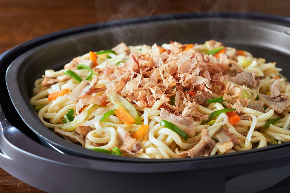 yamaki flakes being poured over rice bowl bringing immediate savory lift