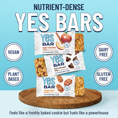 Scattered almonds, cashews, macadamia and seeds beside YES Bar showing ingredients