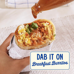 Zab's sauce pouring over pizza slice to add sweet heat and depth